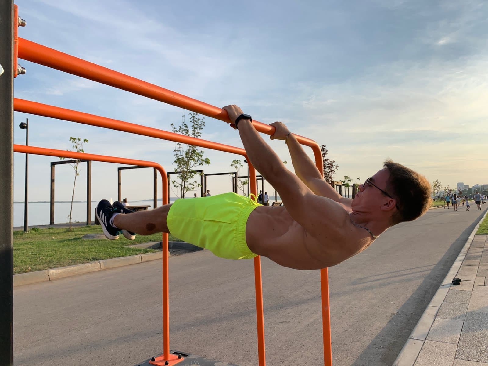 Спортсмен выполняет силовой элемент на уличном турнике