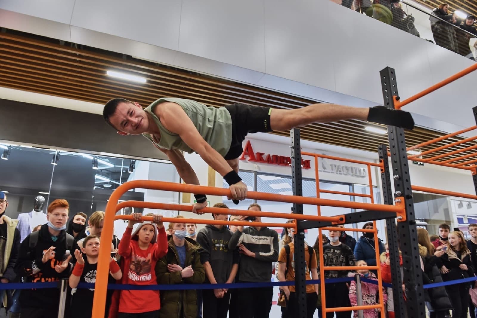 Спортсмен выступает с силовым элементом перед зрителями